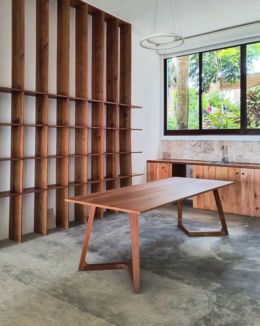 Showroom dining area with a hardwood table and a timber screen dividing the space