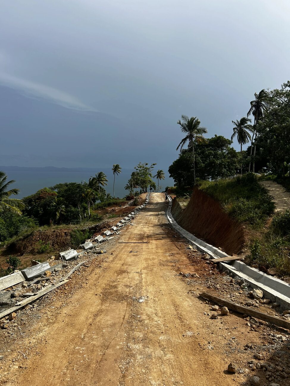 A newly surfaced road with kerbs climbing the hillside at Nomad City
